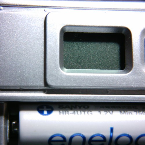 【写真】VistaQuest VQ1005の電池を装着した部分をカバーを外してvitar クローズアップレンズで撮影。