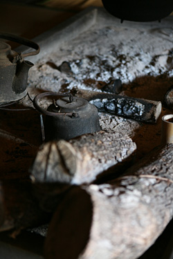 【写真】藤原家住宅の内部2。囲炉裏に置かれた鉄のやかん。
